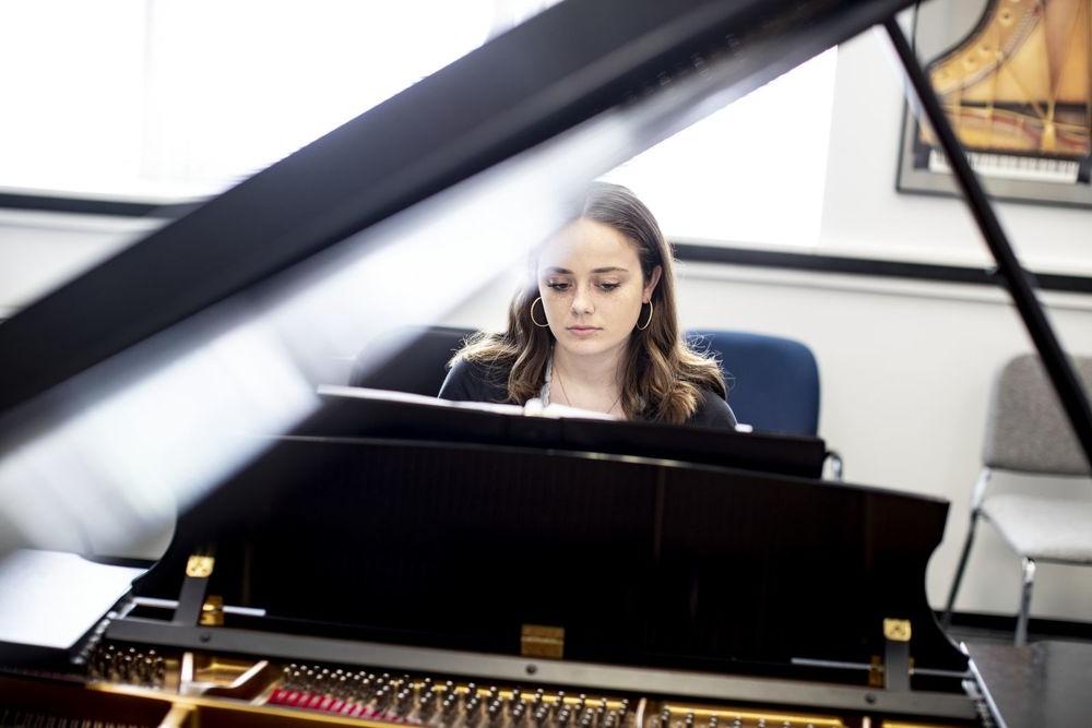 A Boyer College of Music 和 Dance student plays the piano in a rehearsal room on Temple's campus.
